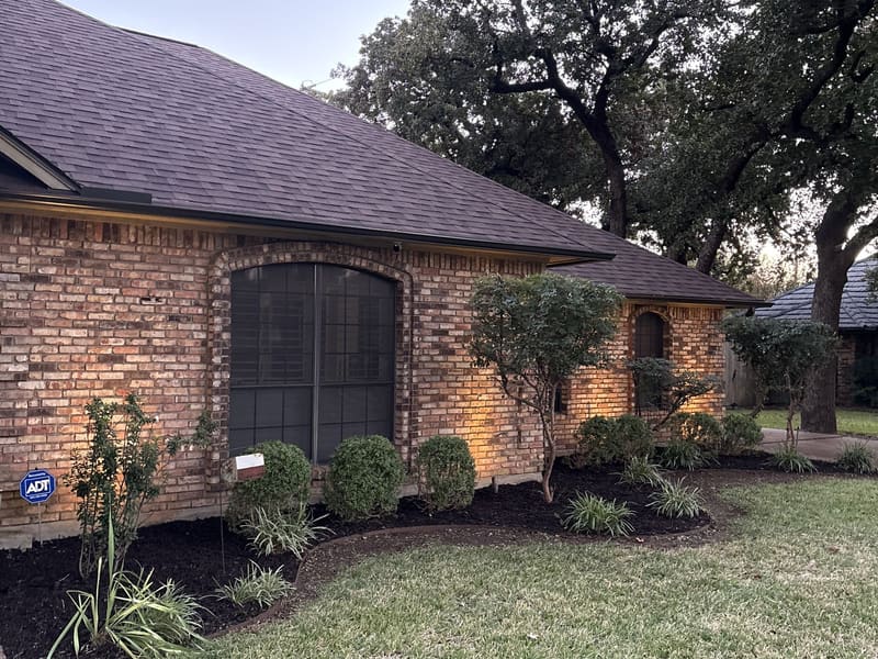 Landscape beds with fresh mulch and lighting at dusk — a Classic Lawncare project