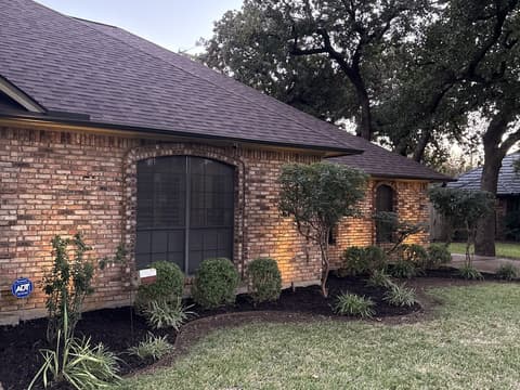 Landscape beds with fresh mulch and lighting at dusk