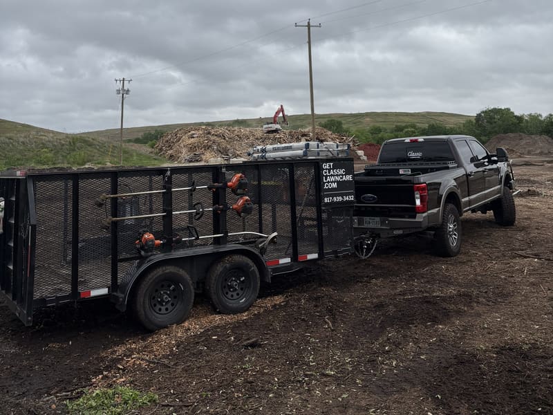 Classic Lawncare truck and dump trailer loaded with debris during a property cleanup
